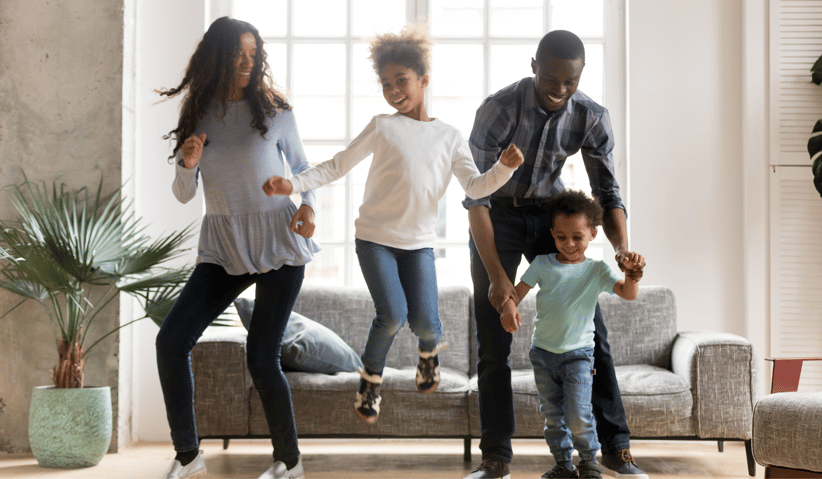Family of 4 dancing in living room 