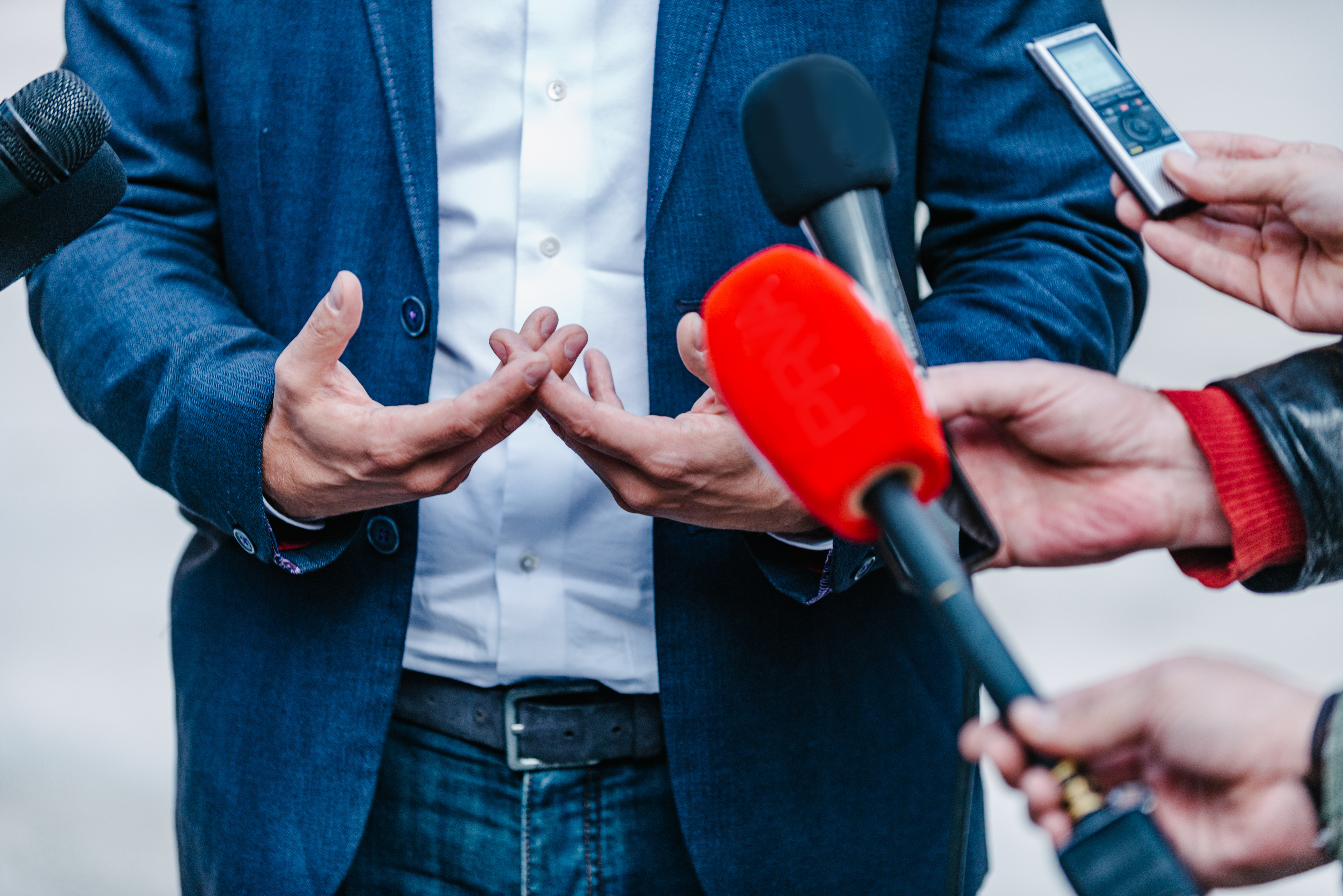 interviewing-businessman-on-press-conference-PAWZS9Q