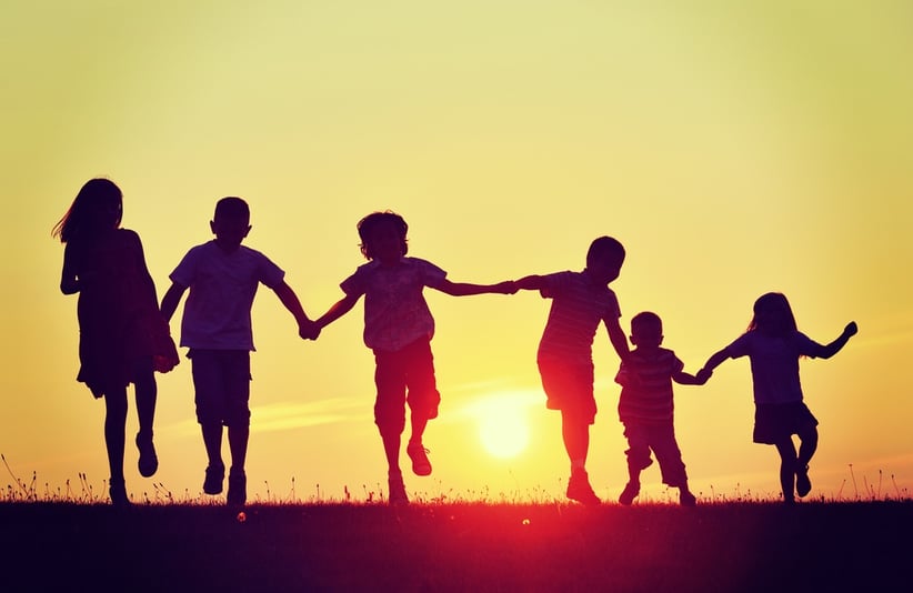 Happy children silhouettes on summer meadow running and jumping.jpeg