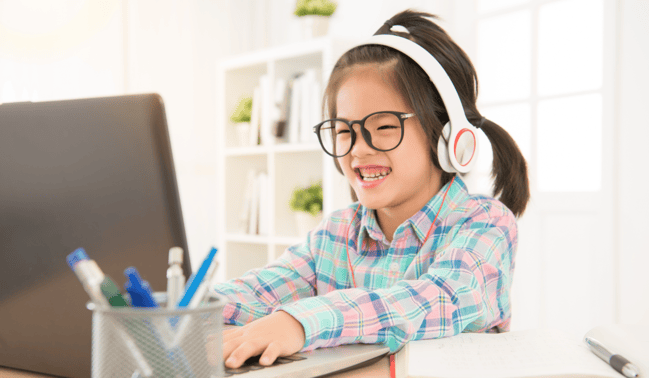 Little girl typing on a laptop