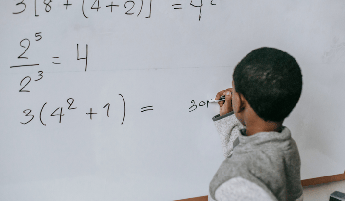 child writing a math problem